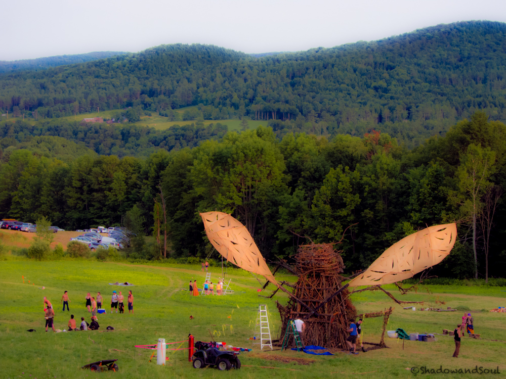 A view from the hill down to the field, where the 2012 bug is surrounded by people.