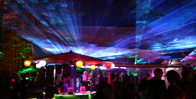 Fireflies dance and talk at a sound camp lit up with with lasers.