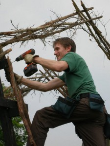 A volunteer uses a power drill on the Bug.